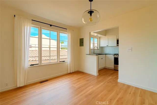 a view of a kitchen with wooden floor and a window