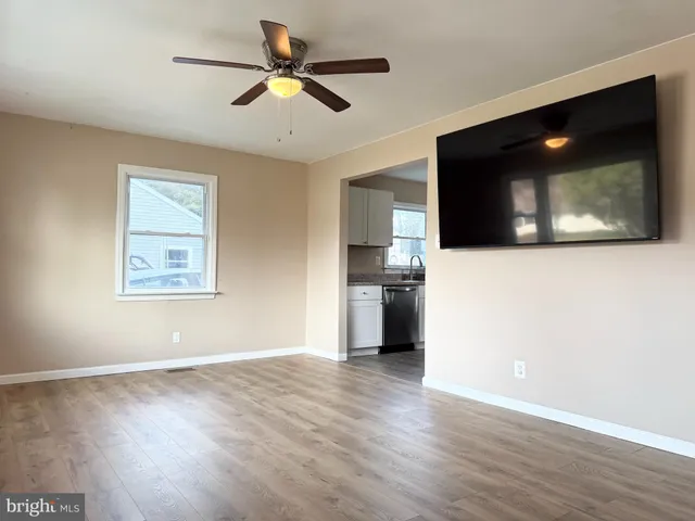a view of a livingroom with wooden floor and a ceiling fan