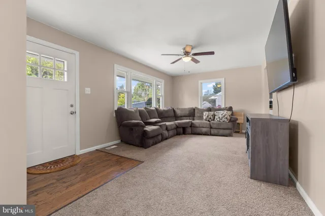 a living room with furniture a ceiling fan and a window