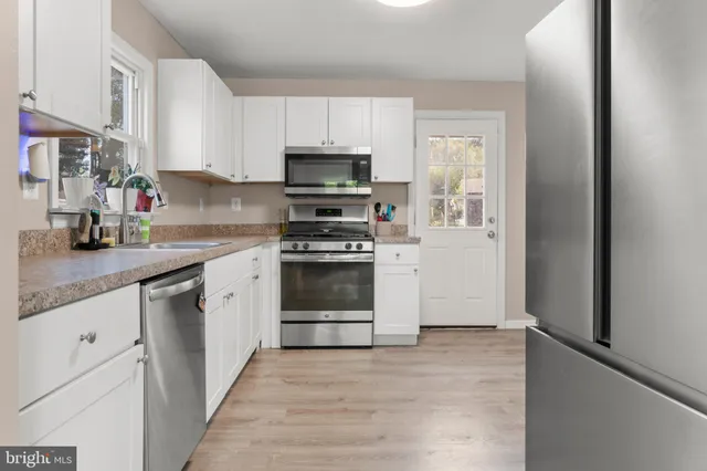 a kitchen with stainless steel appliances granite countertop a stove a sink and a refrigerator