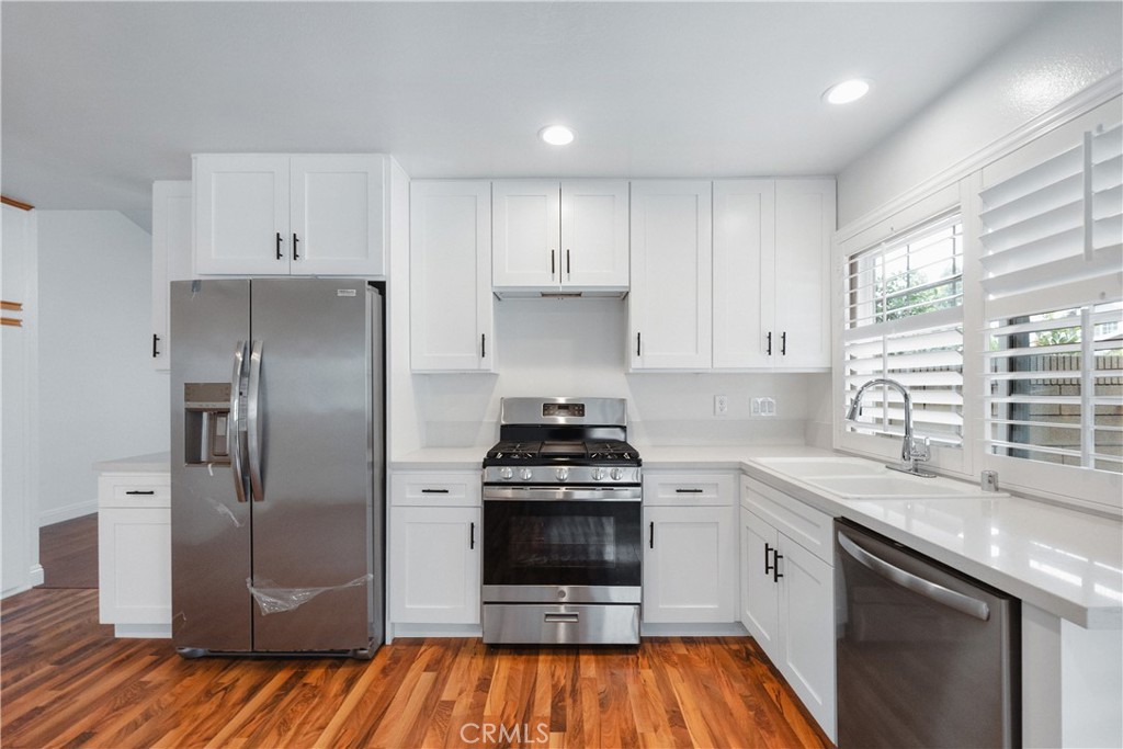 2172 Belhaven Avenue Simi Valley, CA 93063 - Photo 6 of 24 a kitchen with a stove a refrigerator and a sink
