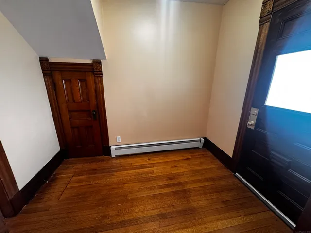 a view of an empty room with wooden floor