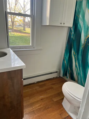a bathroom with a toilet a sink and a window
