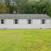 a front view of house with yard and trees around