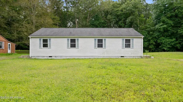 a front view of house with yard and trees around