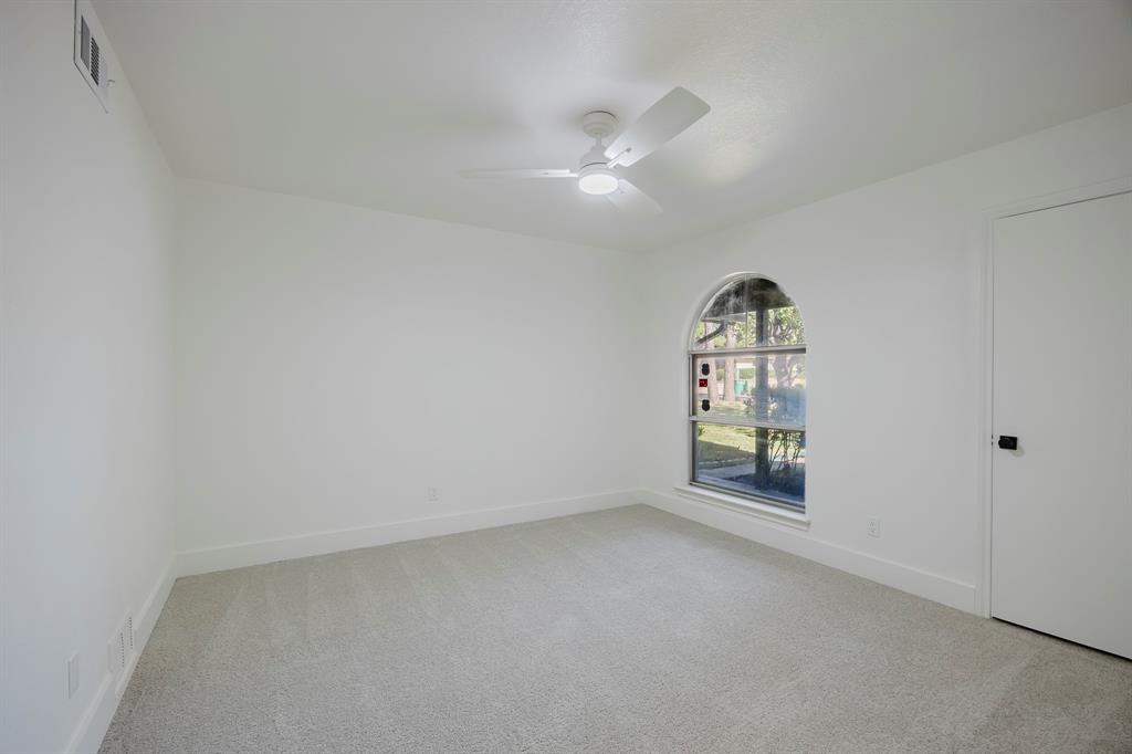 2120 Fairfax Road Denton, TX 76205 - Photo 17 of 23 an empty room with chandelier fan and windows