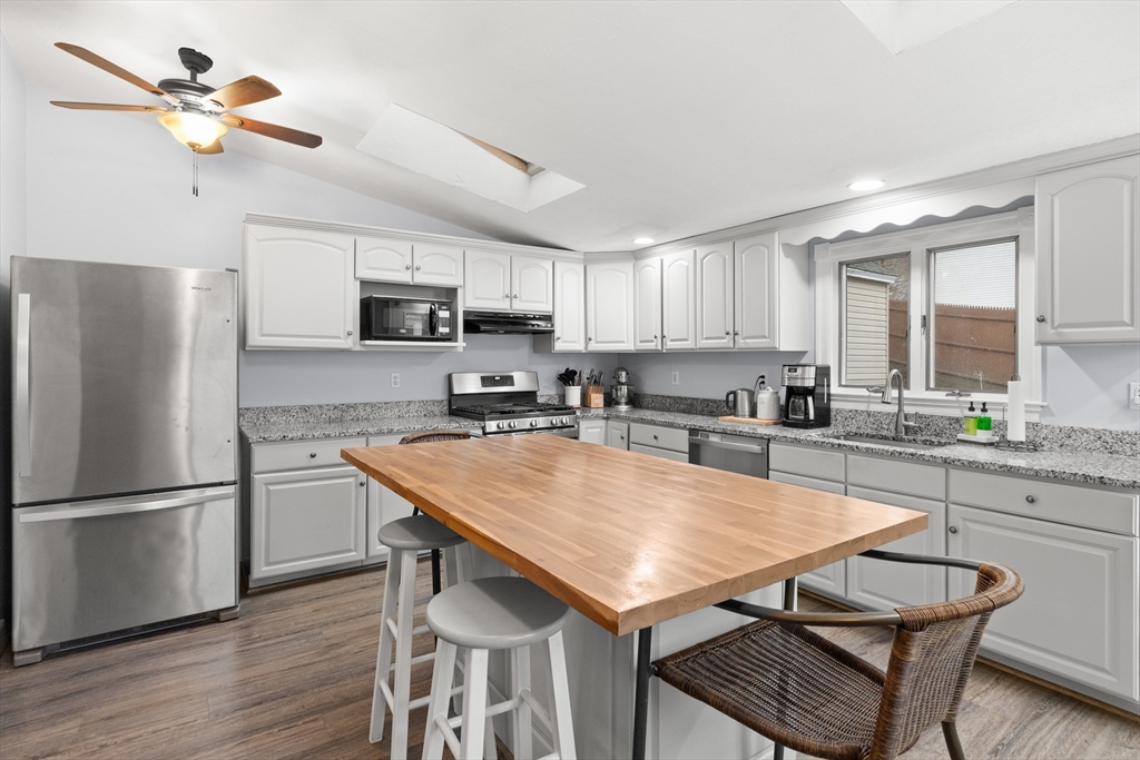 3 Smith Avenue Methuen, MA 01844 - Photo 14 of 38 a kitchen with kitchen island a refrigerator stove microwave and cabinets