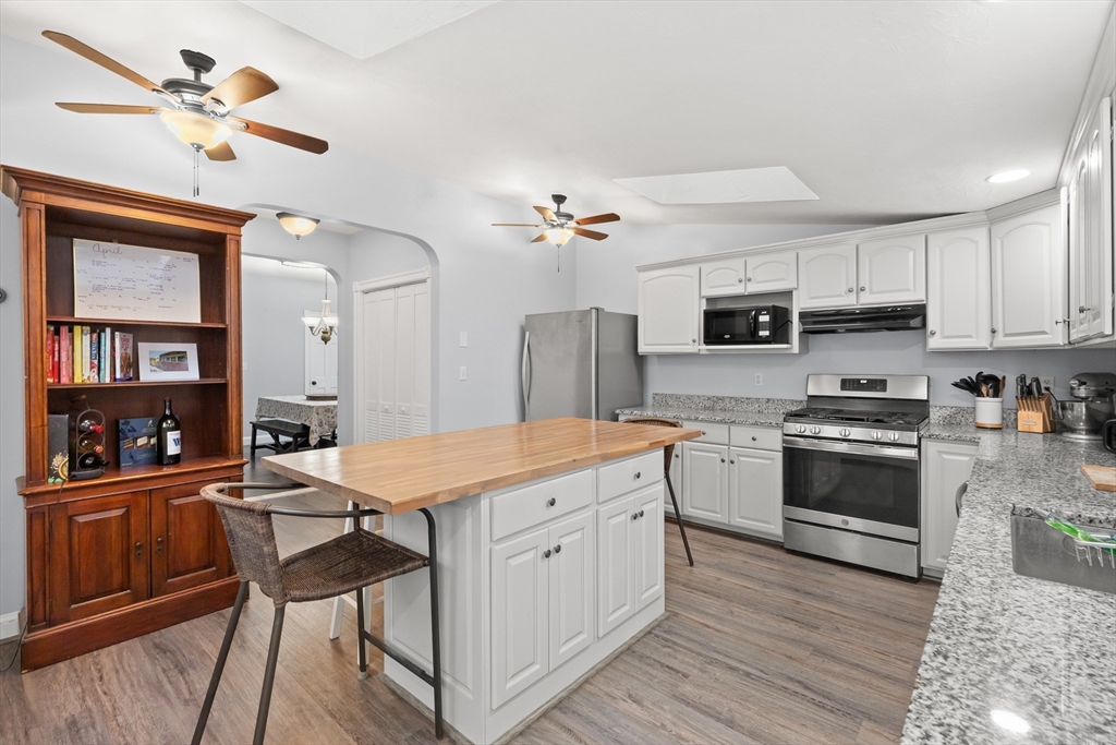 3 Smith Avenue Methuen, MA 01844 - Photo 15 of 38 a kitchen with stainless steel appliances granite countertop a stove a sink dishwasher and a refrigerator with wooden floor