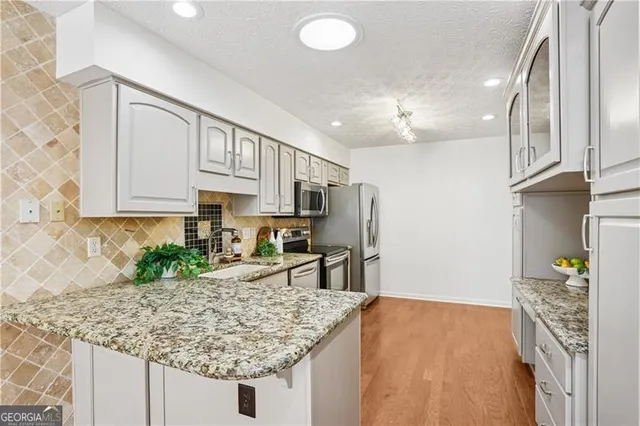 a kitchen with stainless steel appliances granite countertop a sink refrigerator and cabinets
