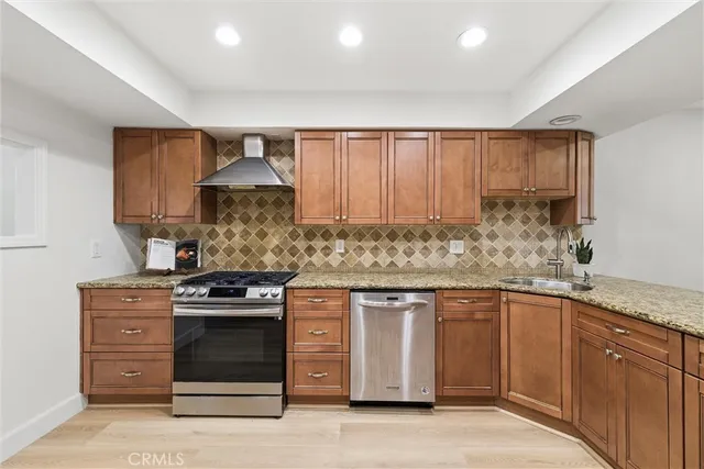 a kitchen with stainless steel appliances granite countertop a refrigerator and a stove top oven
