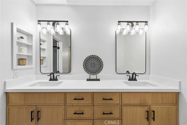 a bathroom with double vanity sinks and a mirror