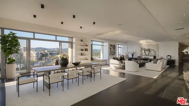 a room with lots of tables a large window and chairs