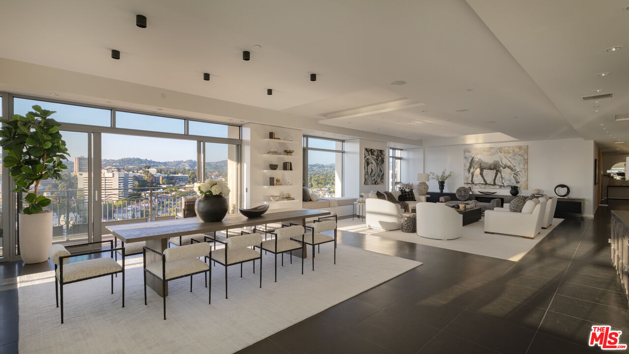 a room with lots of tables a large window and chairs