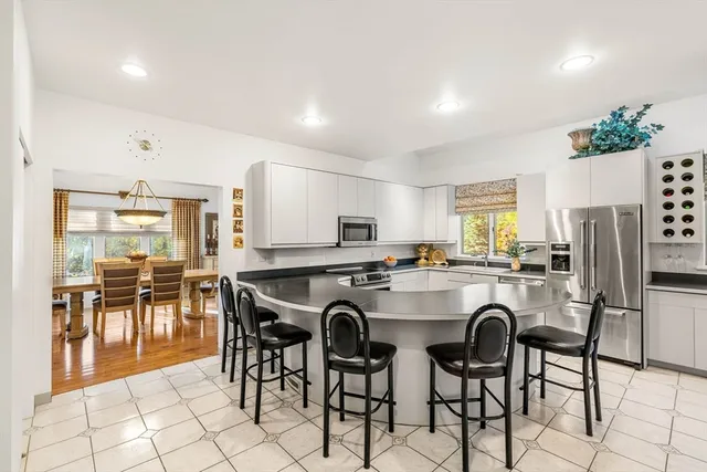 a kitchen with stainless steel appliances a table and chairs in it