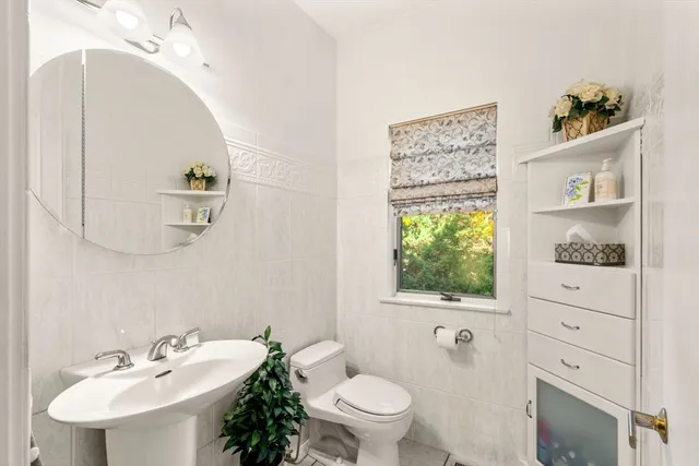 a bathroom with a sink a toilet and mirror