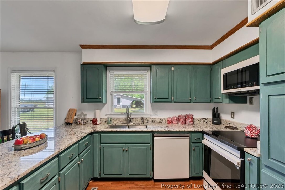 7266 Pleasant Hope Road Fairmont, NC 28340 - Photo 11 of 45 a kitchen with granite countertop a sink stove and cabinets