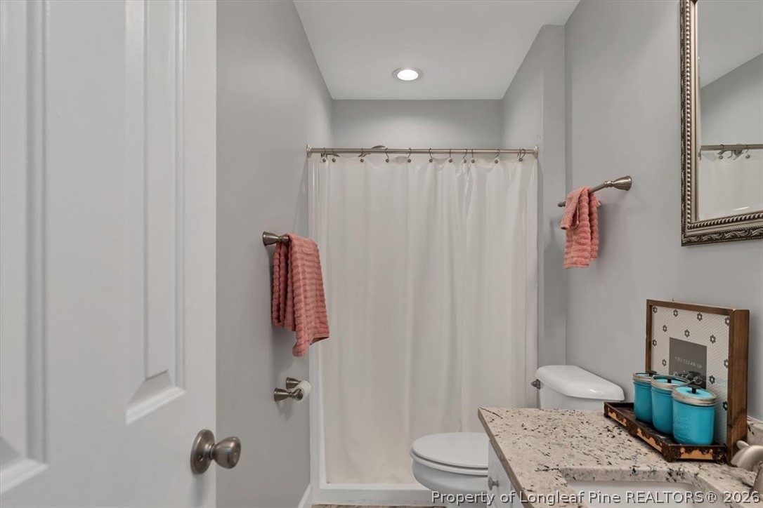 7266 Pleasant Hope Road Fairmont, NC 28340 - Photo 21 of 45 a bathroom with a granite countertop sink a toilet and shower