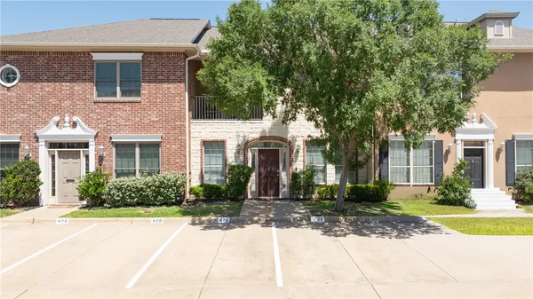 front view of a brick house with a yard
