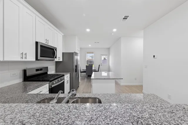 a kitchen with a sink cabinets and wooden floor