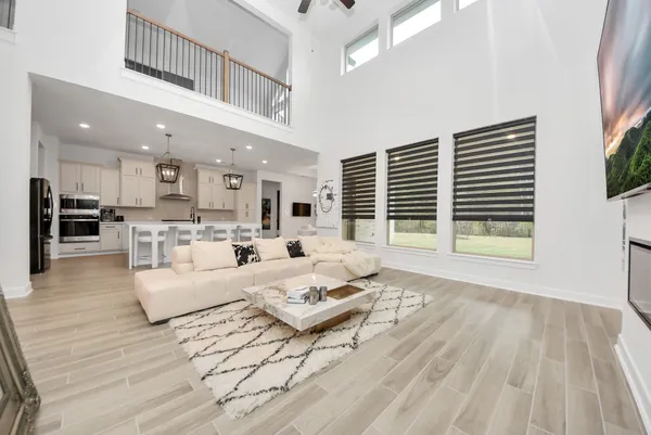 a large kitchen with cabinets wooden floor white stainless steel appliances and dining table