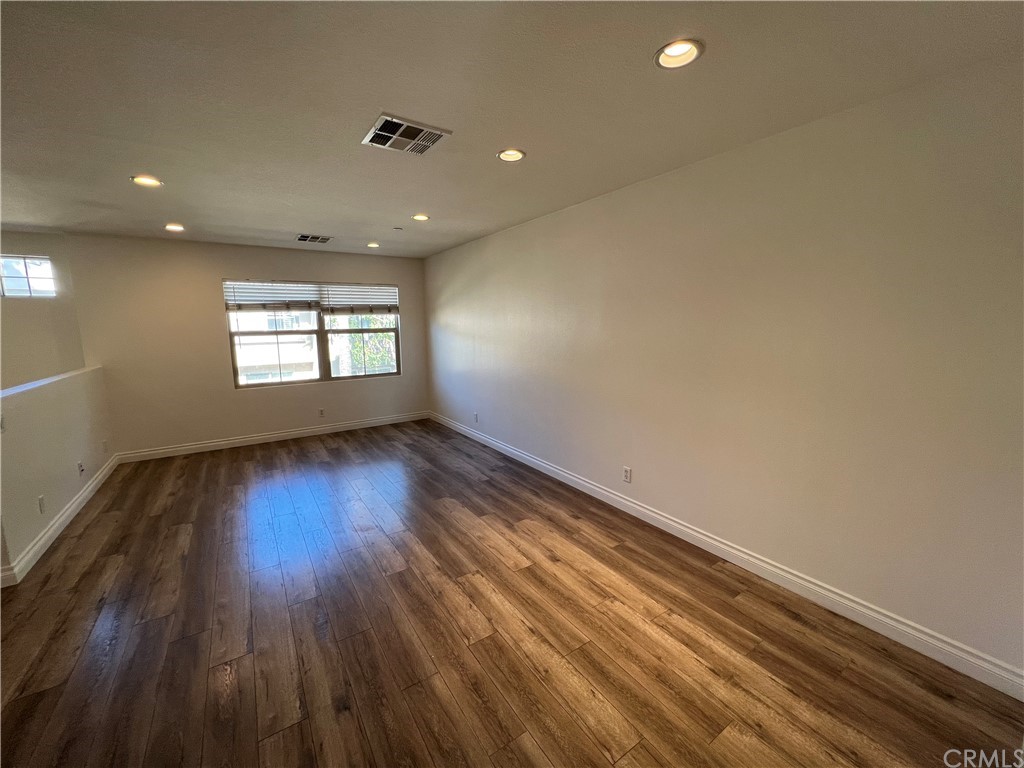 80 Hedge Bloom Irvine, CA 92618 - Photo 5 of 12 an empty room with wooden floor and windows
