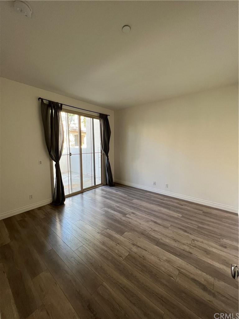 80 Hedge Bloom Irvine, CA 92618 - Photo 7 of 12 a view of an empty room with wooden floor and a window