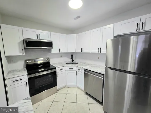 a kitchen with a refrigerator stove and sink