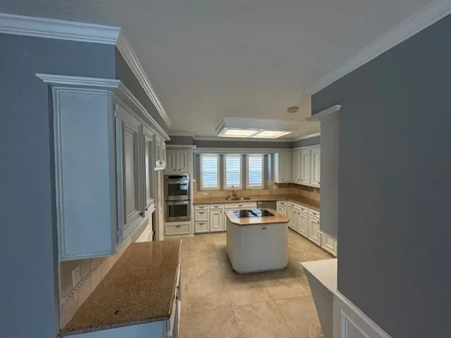 a living room with furniture a large window and a sink
