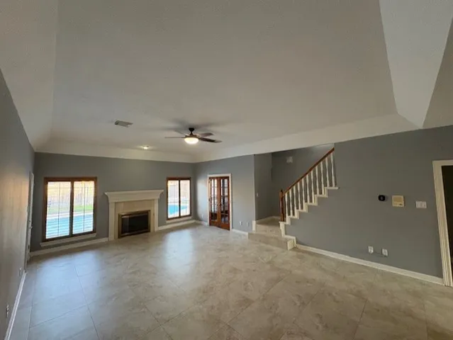 a view of an empty room with a fireplace and a window
