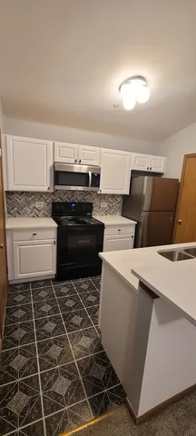 a kitchen with a stove a microwave and a counter top space