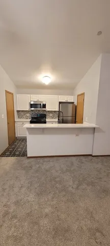 a kitchen with granite countertop a sink and white cabinets