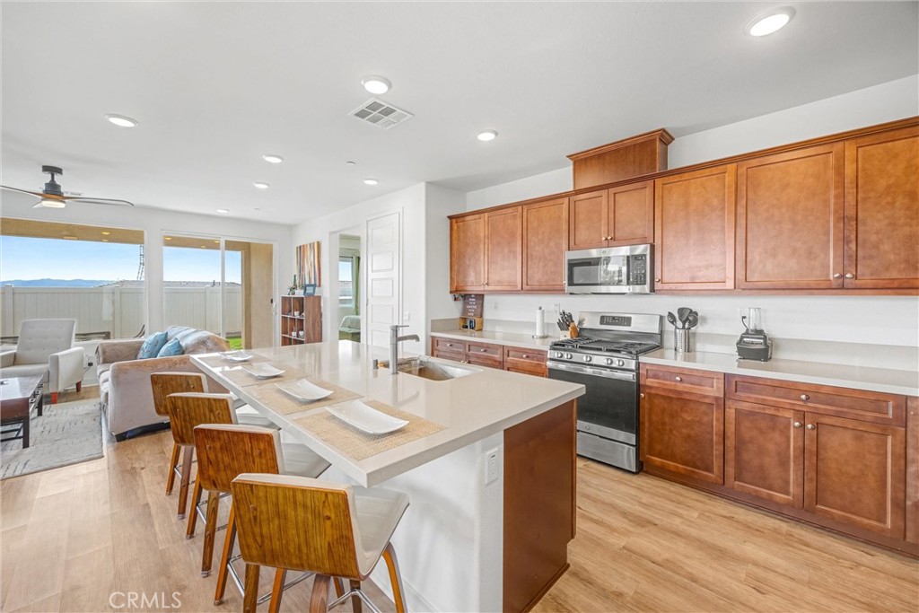 1685 Spring Run Lane Beaumont, CA 92223 - Photo 12 of 57 a large kitchen with kitchen island a sink table and chairs