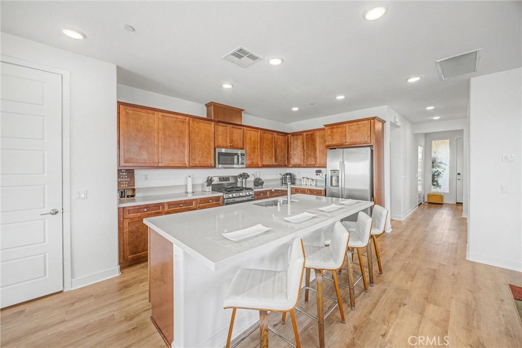 1685 Spring Run Lane Beaumont, CA 92223 - Photo 13 of 57 a large kitchen with kitchen island a stove a sink a refrigerator and cabinets