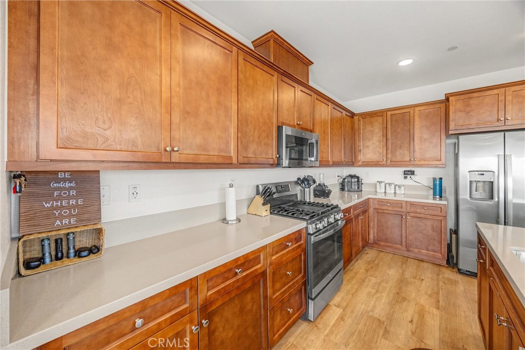 1685 Spring Run Lane Beaumont, CA 92223 - Photo 14 of 57 a kitchen with stainless steel appliances granite countertop a sink and cabinets