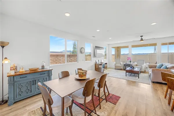 a dining room with stainless steel appliances a dining table wooden floor and a kitchen view