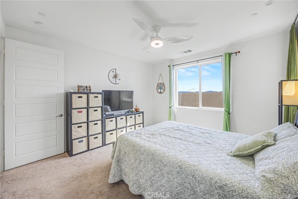 1685 Spring Run Lane Beaumont, CA 92223 - Photo 29 of 57 a bedroom with a bed a dresser and a large window