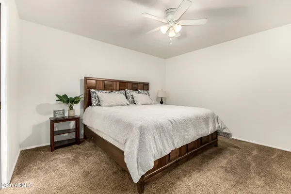a bedroom with a bed and a chandelier fan