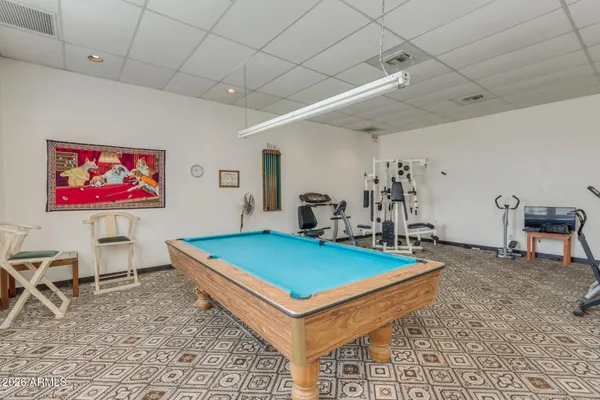 a room with pool table and windows