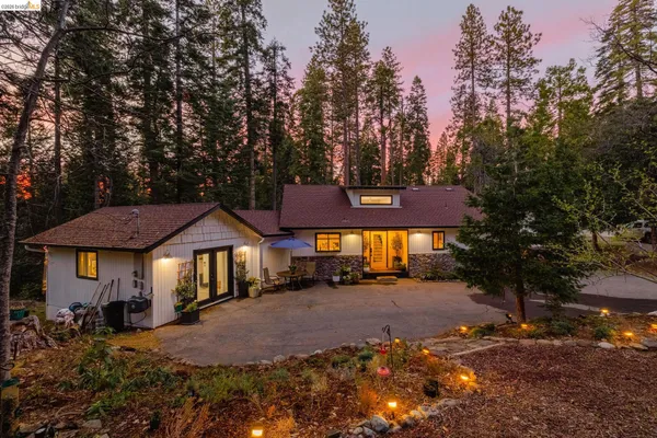 a front view of a house with a yard and trees