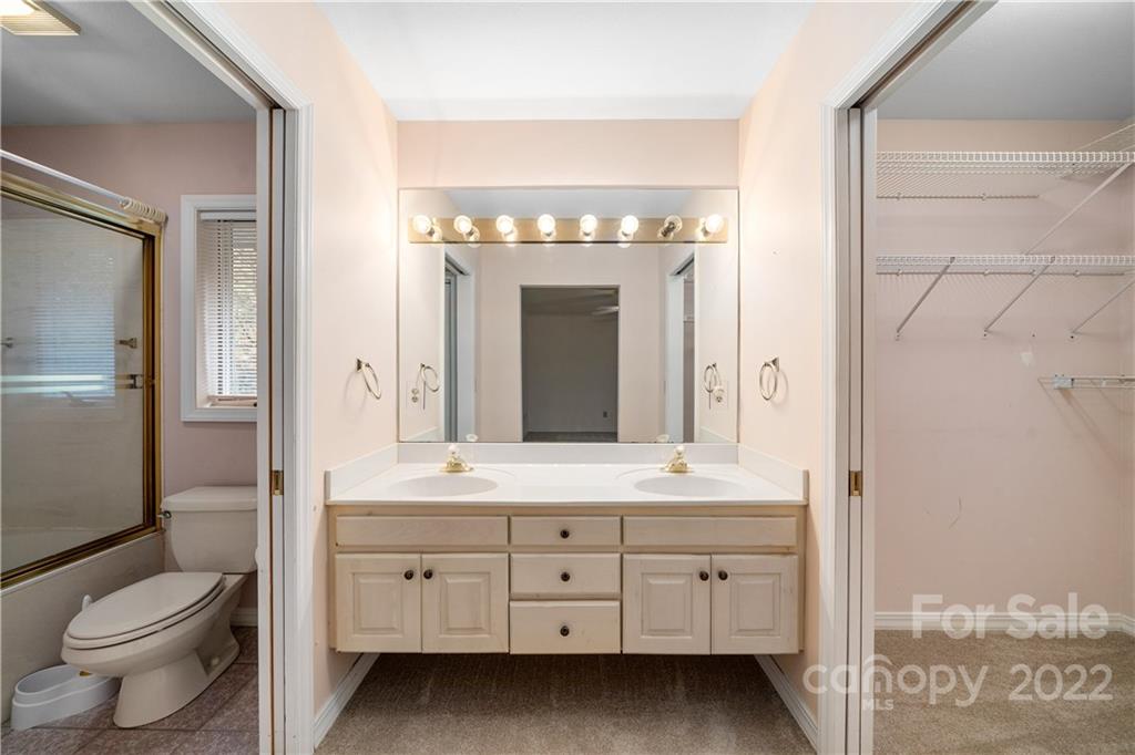 592 Mouzon Road Waynesville, NC 28785 - Photo 13 of 38 a spacious bathroom with a granite countertop toilet a sink and a mirror