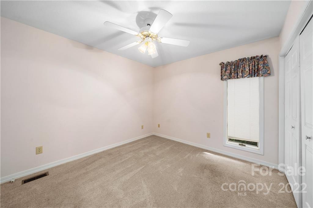 592 Mouzon Road Waynesville, NC 28785 - Photo 14 of 38 an empty room with a chandelier fan and a window