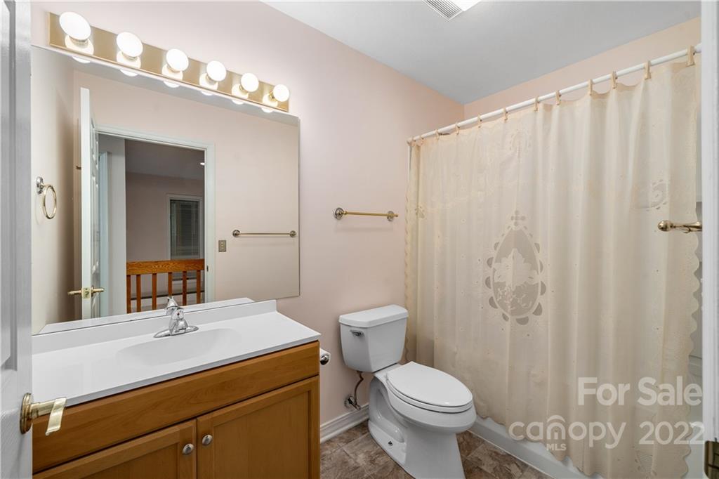 592 Mouzon Road Waynesville, NC 28785 - Photo 15 of 38 a bathroom with a sink a toilet and shower curtain