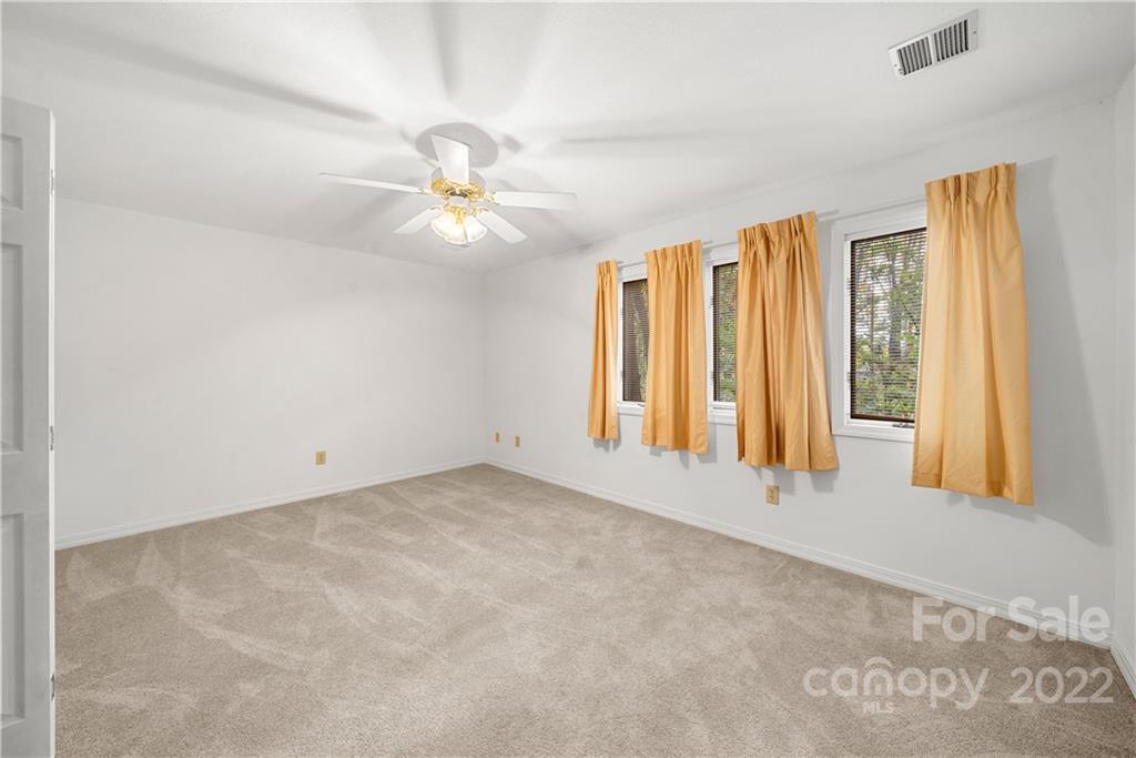592 Mouzon Road Waynesville, NC 28785 - Photo 21 of 38 an empty room with windows and chandelier fan