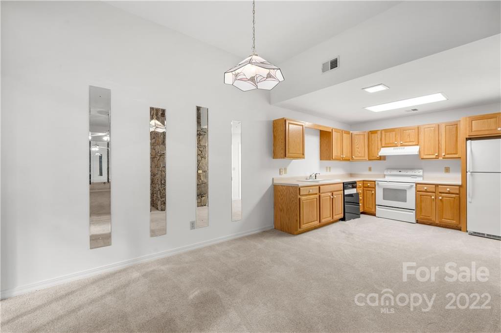 592 Mouzon Road Waynesville, NC 28785 - Photo 26 of 38 a large white kitchen with a large window and stainless steel appliances