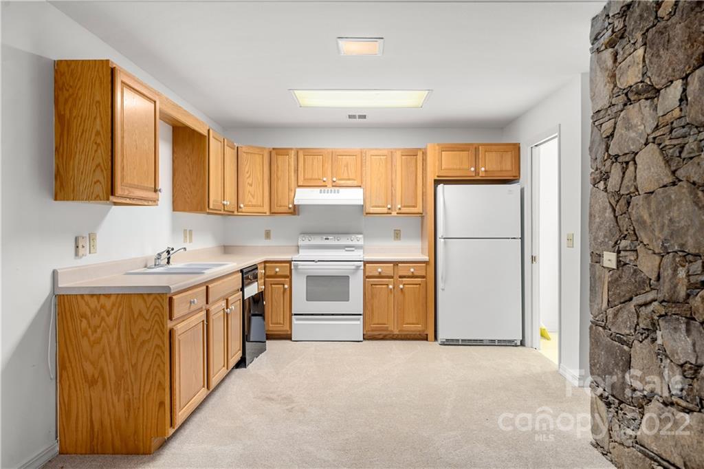 592 Mouzon Road Waynesville, NC 28785 - Photo 27 of 38 a kitchen with a sink a refrigerator and a window