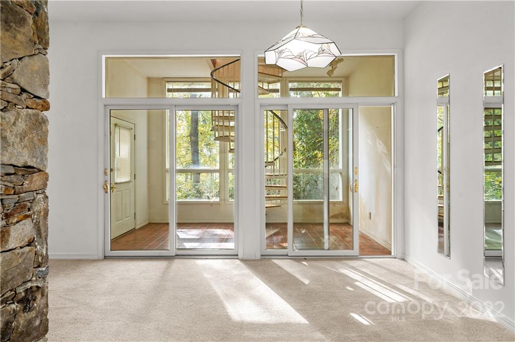 592 Mouzon Road Waynesville, NC 28785 - Photo 28 of 38 a view of a room with large windows and a chandelier