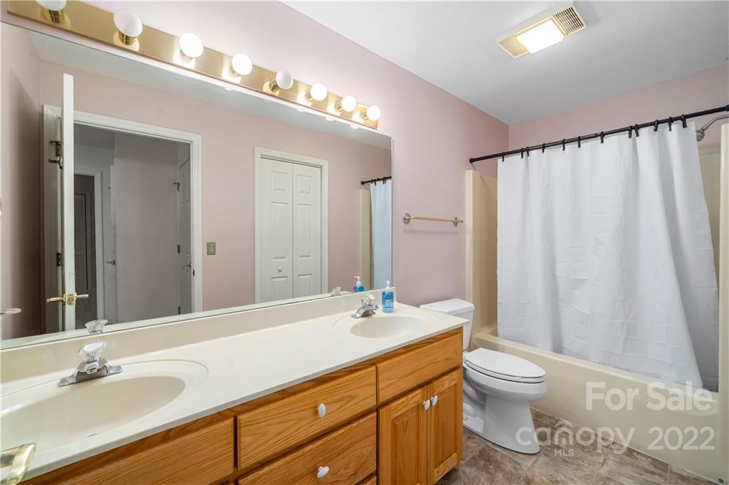 592 Mouzon Road Waynesville, NC 28785 - Photo 33 of 38 a bathroom with a granite countertop sink a toilet and a mirror