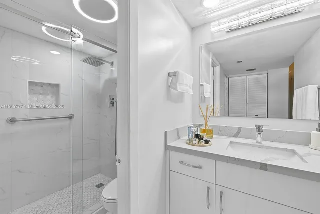 a bathroom with a shower sink vanity and mirror
