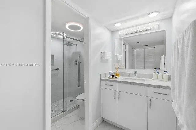 a bathroom with a double vanity sink toilet mirror and shower
