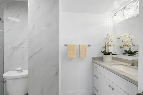 a bathroom with a granite countertop sink a toilet and mirror